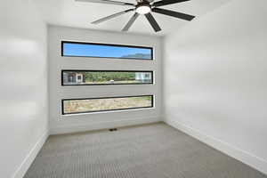 Carpeted spare room with baseboards and a ceiling fan