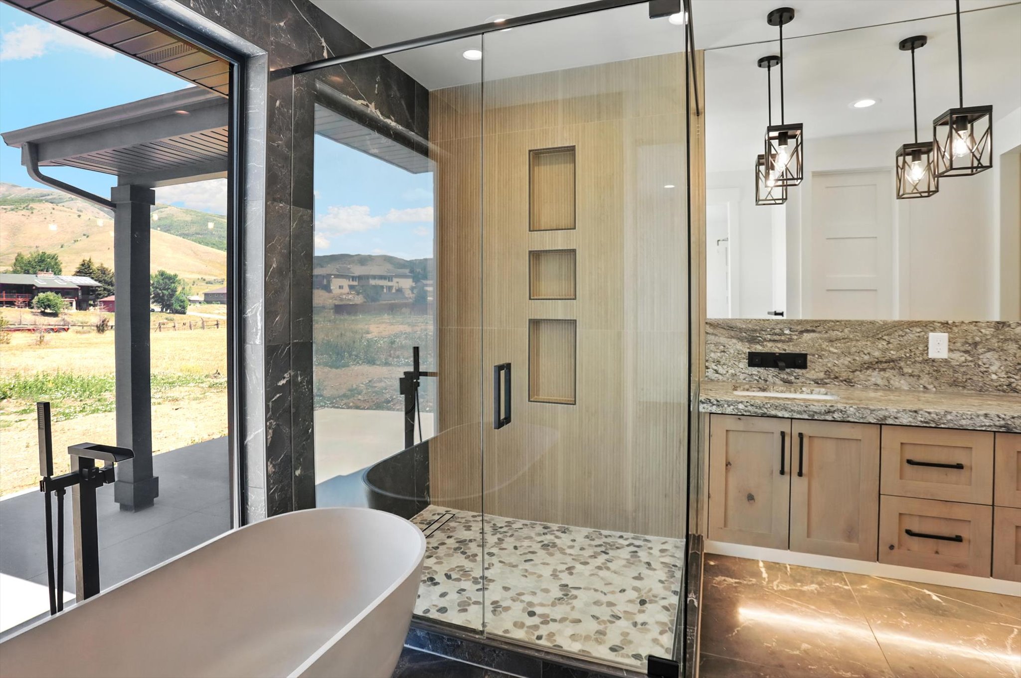 Kitchen with light stone countertops, pendant lighting, recessed lighting, and light brown cabinets