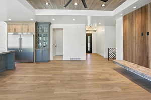Kitchen featuring stainless steel built in fridge, recessed lighting, light wood finished floors, ceiling fan, and glass insert cabinets