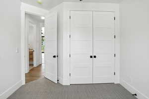 Unfurnished bedroom with carpet flooring and a closet