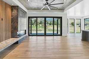 Unfurnished living room with recessed lighting, wood-type flooring, wooden ceiling, a premium fireplace, and a ceiling fan