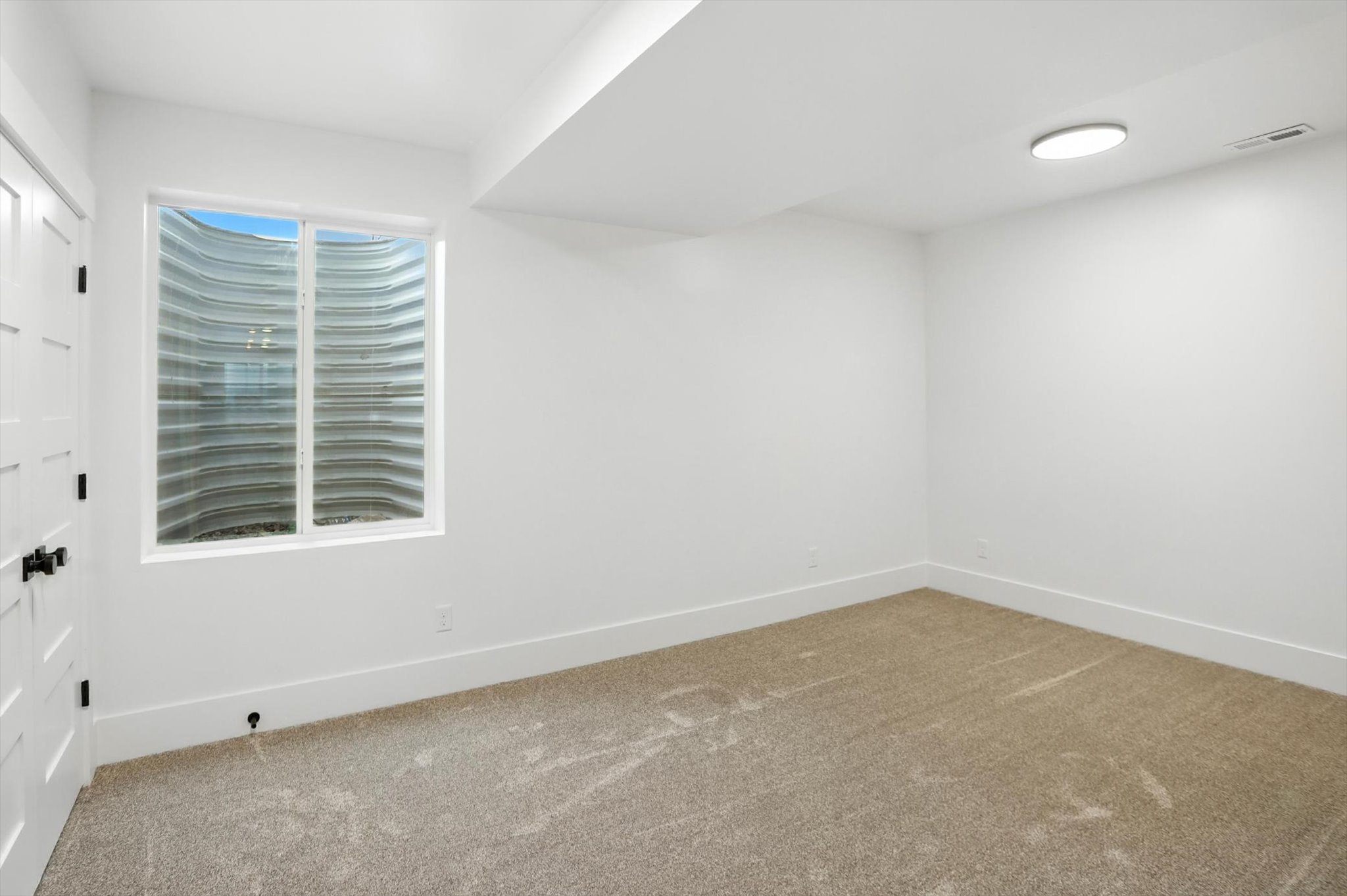 Carpeted spare room featuring baseboards
