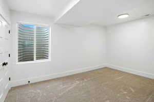 Carpeted spare room featuring baseboards
