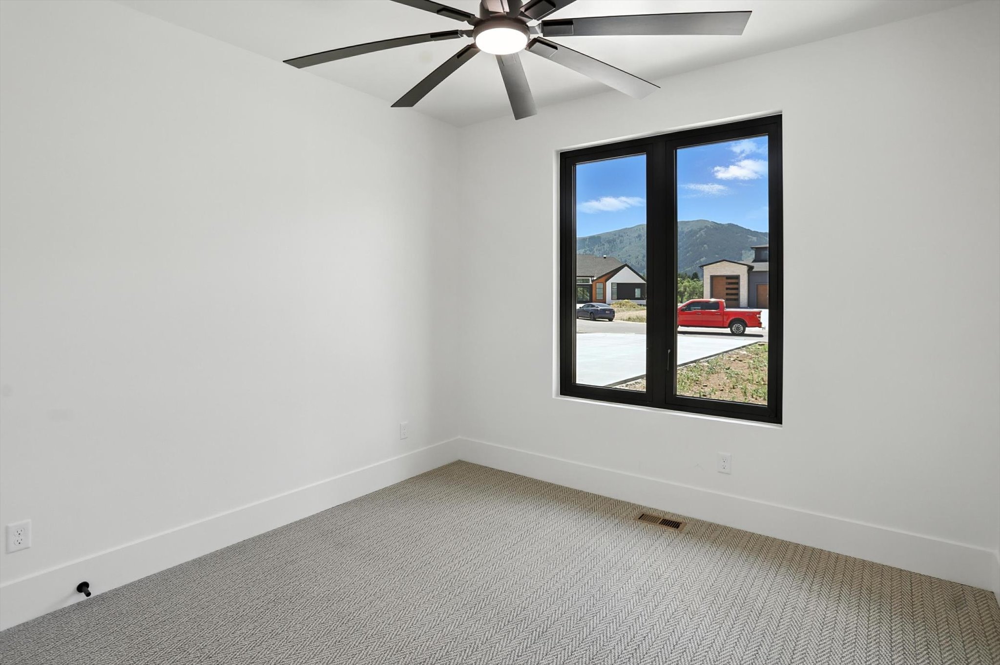 Spare room featuring light carpet and ceiling fan