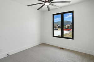 Spare room featuring light carpet and ceiling fan