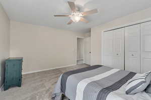 Bedroom featuring carpet flooring, baseboards, a closet, and ceiling fan