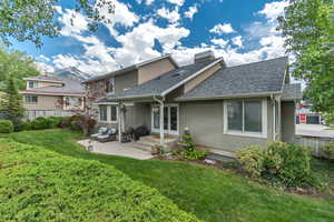 Back of property featuring stucco siding, a shingled roof, a patio area, an outdoor living space, and french doors