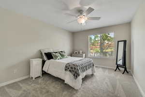 Bedroom with light carpet, baseboards, and ceiling fan