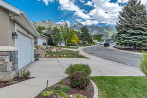 View of road featuring a mountain view, a residential view, sidewalks, and curbs