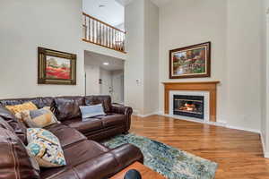 Living area with light wood-style floors, a tiled fireplace, and baseboards