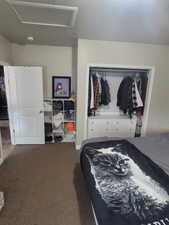 Bedroom featuring attic access, a closet, and carpet flooring