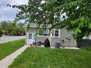 Rear view of house featuring central air condition unit