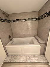 Full bath with a combined bath / shower with jetted tub