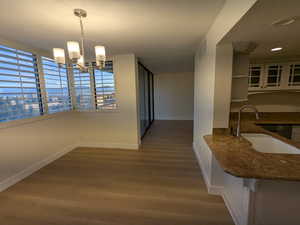 Dining room with baseboards, wood finished floors, and a chandelier