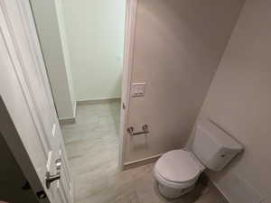 Bathroom featuring baseboards and toilet