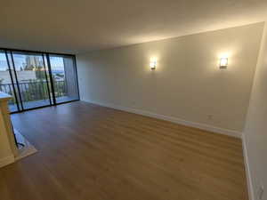 Living room with baseboards, hardwood / wood-style floors, and expansive windows
