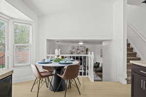 Dining room featuring light wood-style flooring, stairway, and baseboards