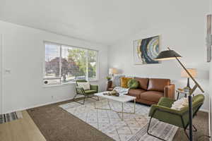 Living room with baseboards, vaulted ceiling, and wood finished floors