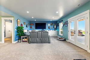 Basement family room with a walk out to a patio.  Recessed lighting and automated blinds.