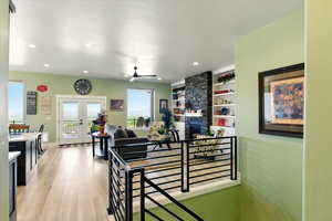 Corridor featuring french doors, light wood-style flooring, recessed lighting, baseboards, and built in shelves