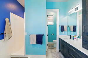 Primary Bathroom with vanity, wood finished floors, and a walk in shower