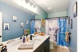 Full bath with vanity, wood finished floors, and a shower with curtain