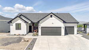 Modern farmhouse style home featuring hardi board siding ,  3 car garage, an asphalt shingled roof, and concrete driveway
