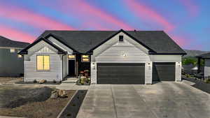 Modern farmhouse featuring a garage,  board and batten siding, concrete driveway, and roof with shingles