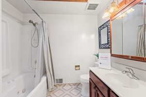 Full bath with shower / bathtub combination with curtain, vanity, and light tile patterned floors