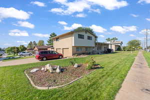 View of front of house featuring driveway, covered porch, and a front yard