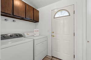 Washroom featuring cabinet space and washing machine and dryer