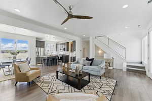 Living area with stairway, wood finished floors, a ceiling fan, recessed lighting, and baseboards