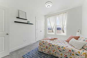 Bedroom with carpet floors, baseboards, and a closet