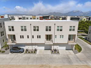 View of building exterior with a mountain view, a garage, and concrete driveway