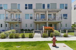Multi unit property with a pergola and stucco siding