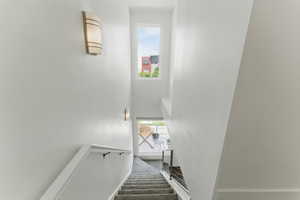 Stairway with a high ceiling and baseboards