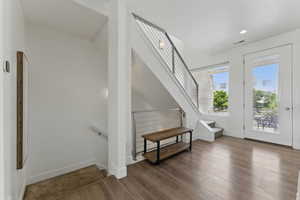 Foyer with wood finished floors, baseboards, stairs, and recessed lighting