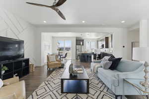 Living area with a ceiling fan, dark wood-type flooring, and recessed lighting