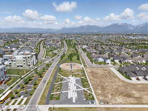 Aerial view of property and surrounding area featuring mountains and nearby suburban area