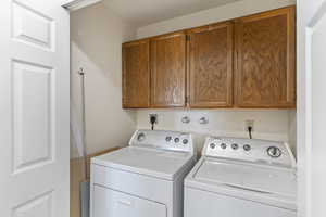 Laundry room with washing machine and clothes dryer and cabinet space