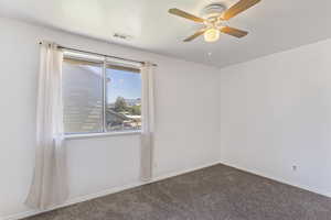 Empty room featuring carpet and a ceiling fan
