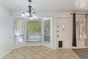Foyer featuring light tile patterned floors and a chandelier