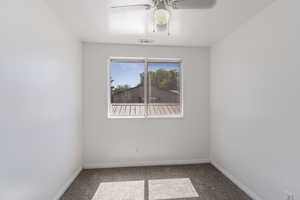 Empty room with carpet, a ceiling fan, and a textured ceiling
