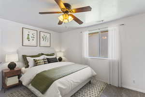 Bedroom with ceiling fan and carpet floors. Photo has been virtually staged.