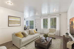 Carpeted living area with healthy amount of natural light. Photo has been virtually staged.