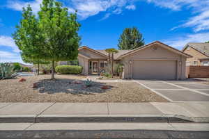 View of front of home with a garage, driveway and a tile roof