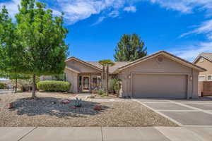 Ranch-style home featuring an attached garage, stucco siding, driveway, and a tile roof