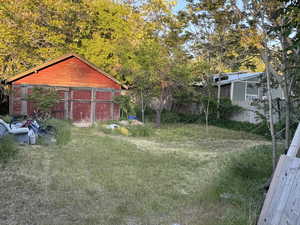 View of yard featuring a garage and an outbuilding