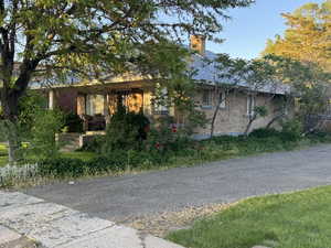 View of front of property featuring brick siding and a chimney