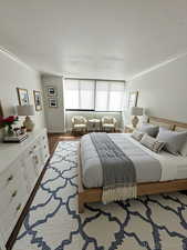 Bedroom with crown molding and dark wood-type flooring